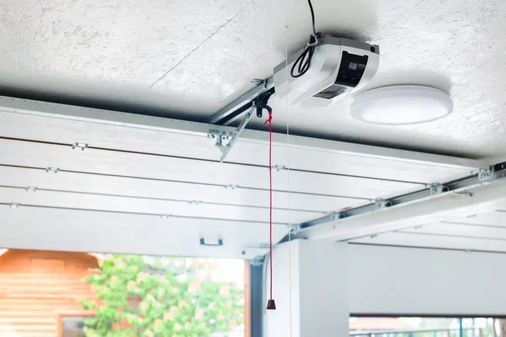 Ceiling-mounted garage door opener system with emergency release cord