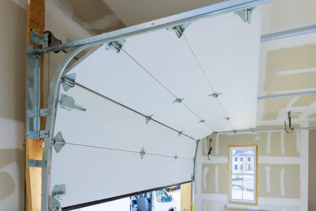 Interior view of garage door track and opener system in newly finished garage